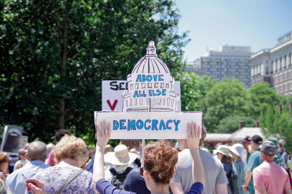 Above all else democracy Woman holding a sign that reads "Above all else Democracy"